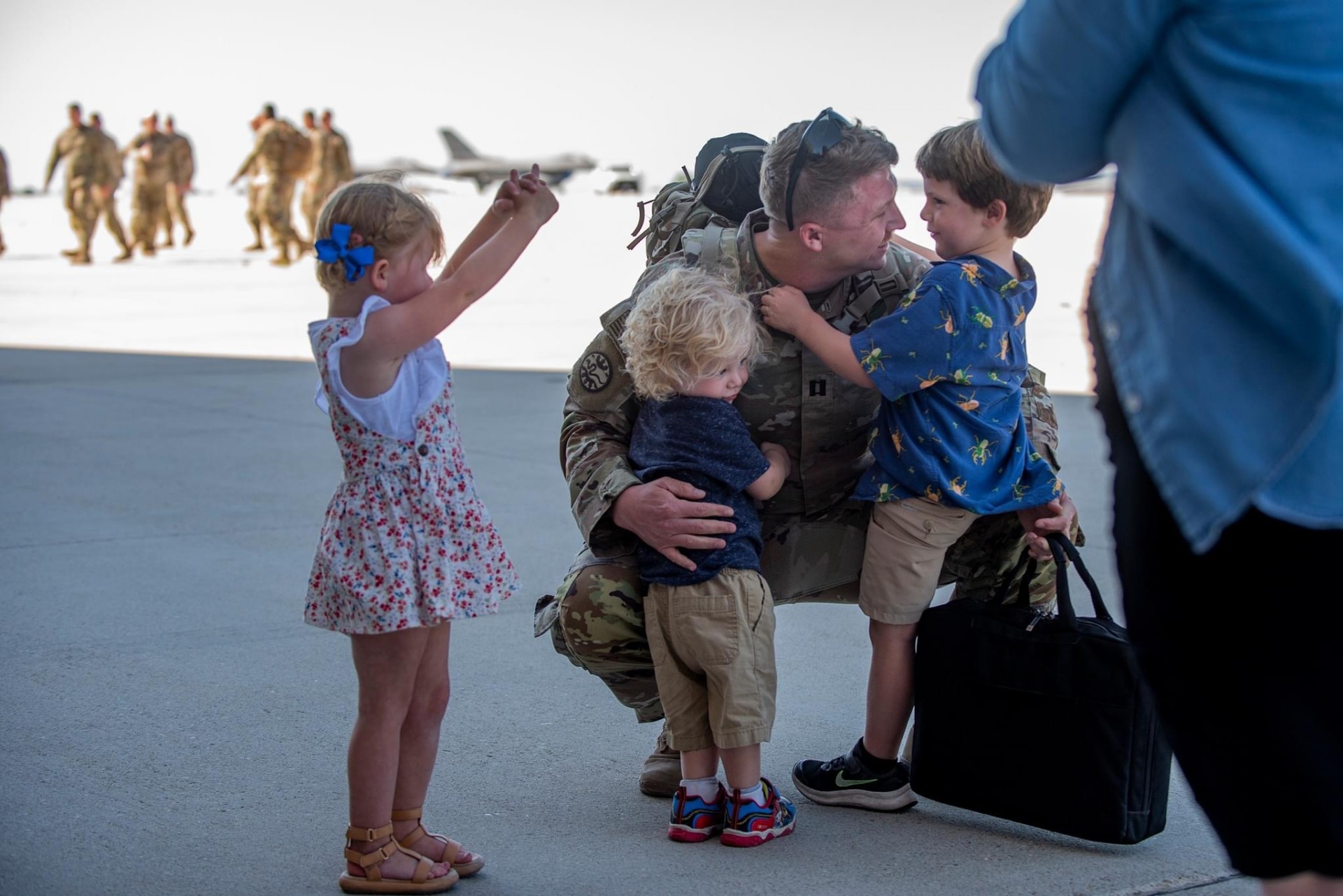 Jeremy C. Rausch reuniting with his children on the flight line after deployment